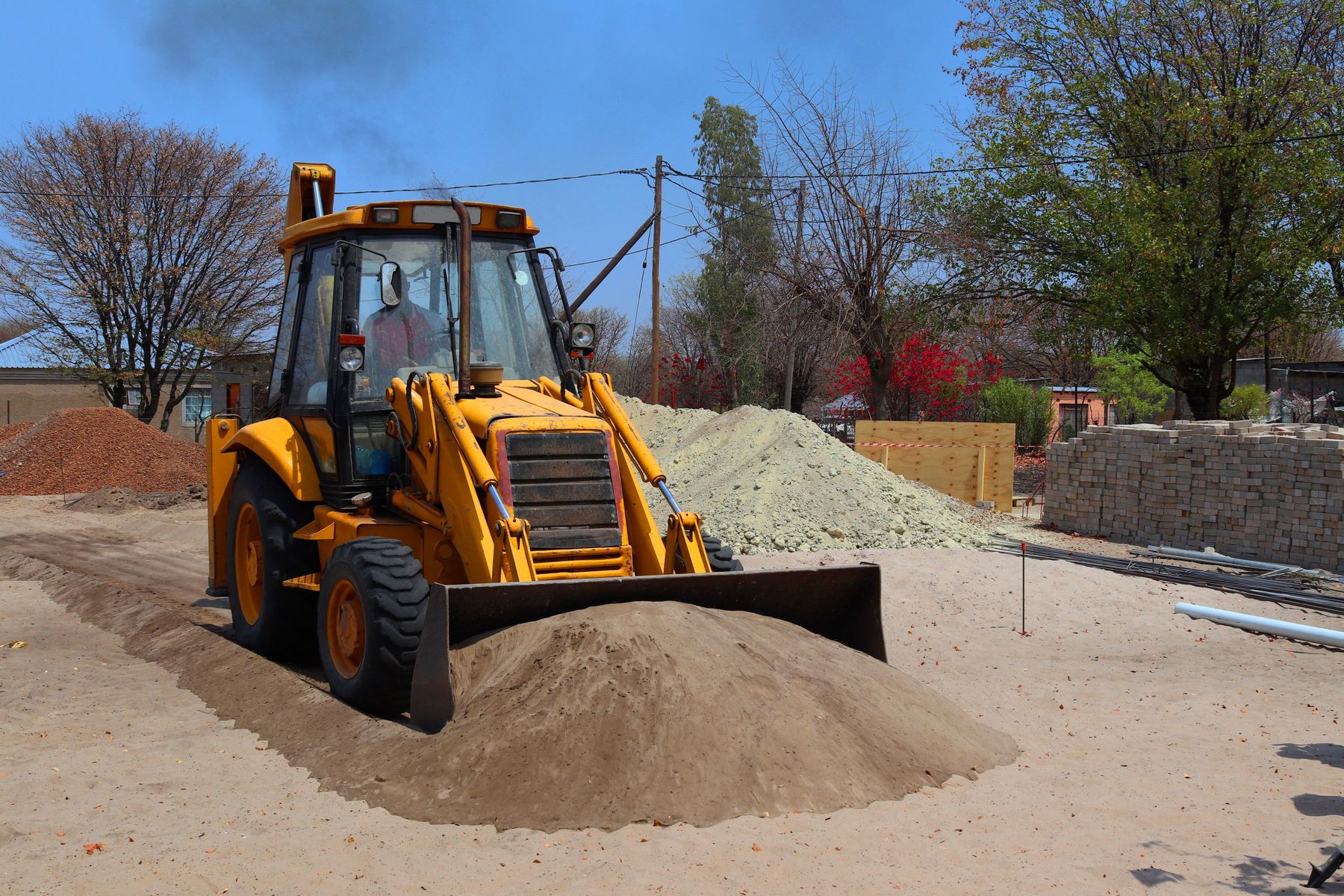 Backhoe loader moving gravel